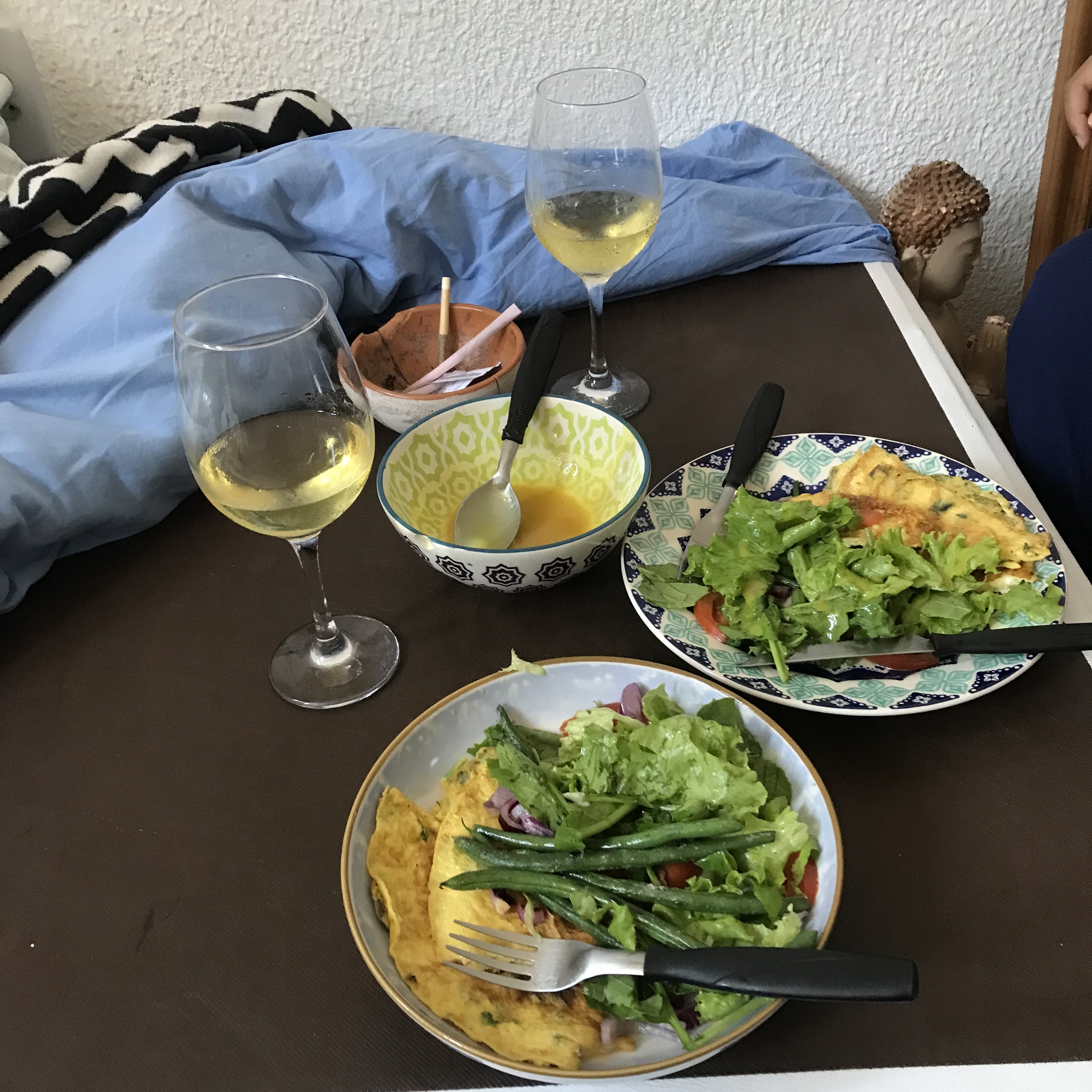 mesa posta: omelete, salada e dois copos de vinho branco